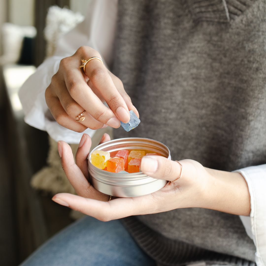 Imagen de una persona cogiendo unas gummies de cbd de un frasquito